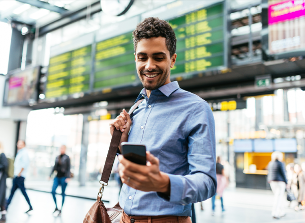Business traveller at the airport checking his mobile phone