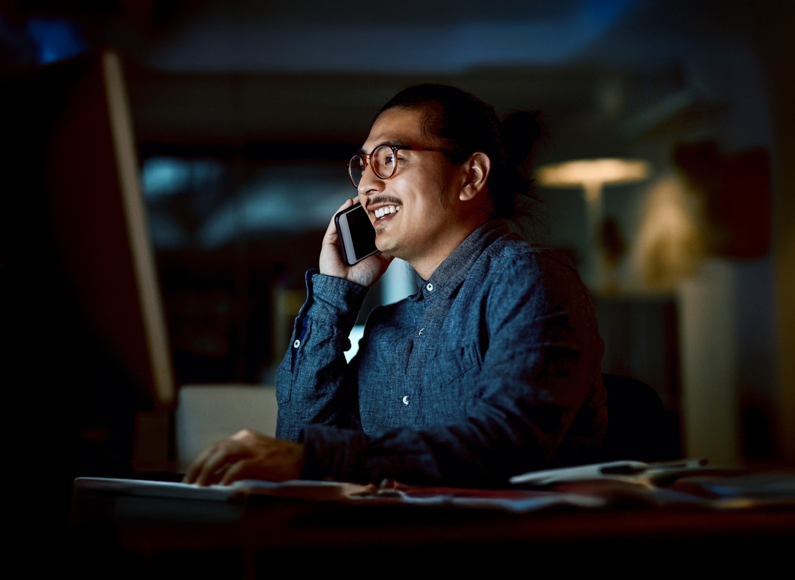Business man on mobile phone in an office managing emergency response travel