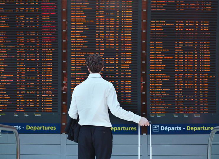 Business traveler reading departure board during the 2026 middle east airspace closure