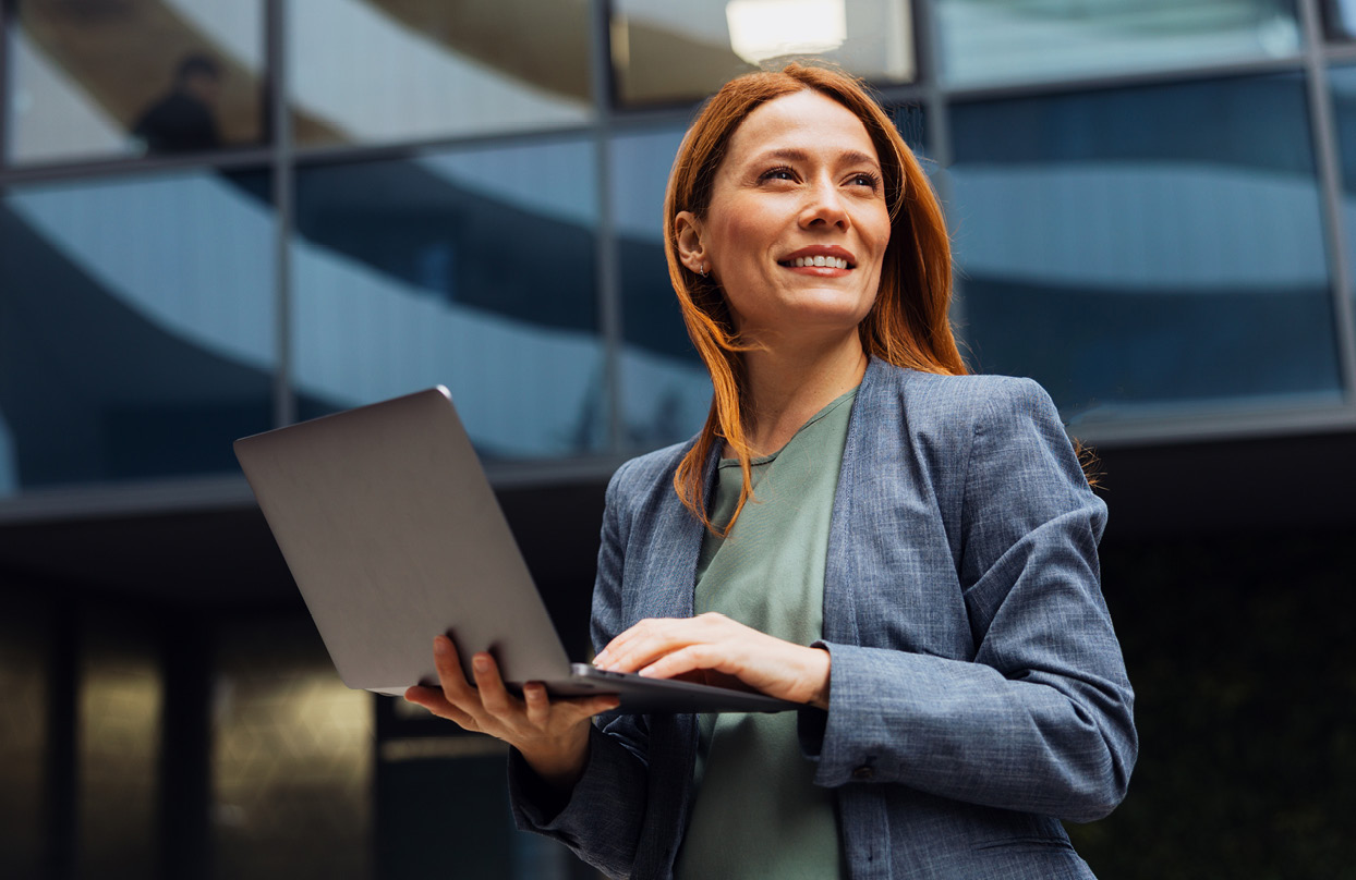 Businesswoman researching CTM's strategic account travel management solutions on laptop